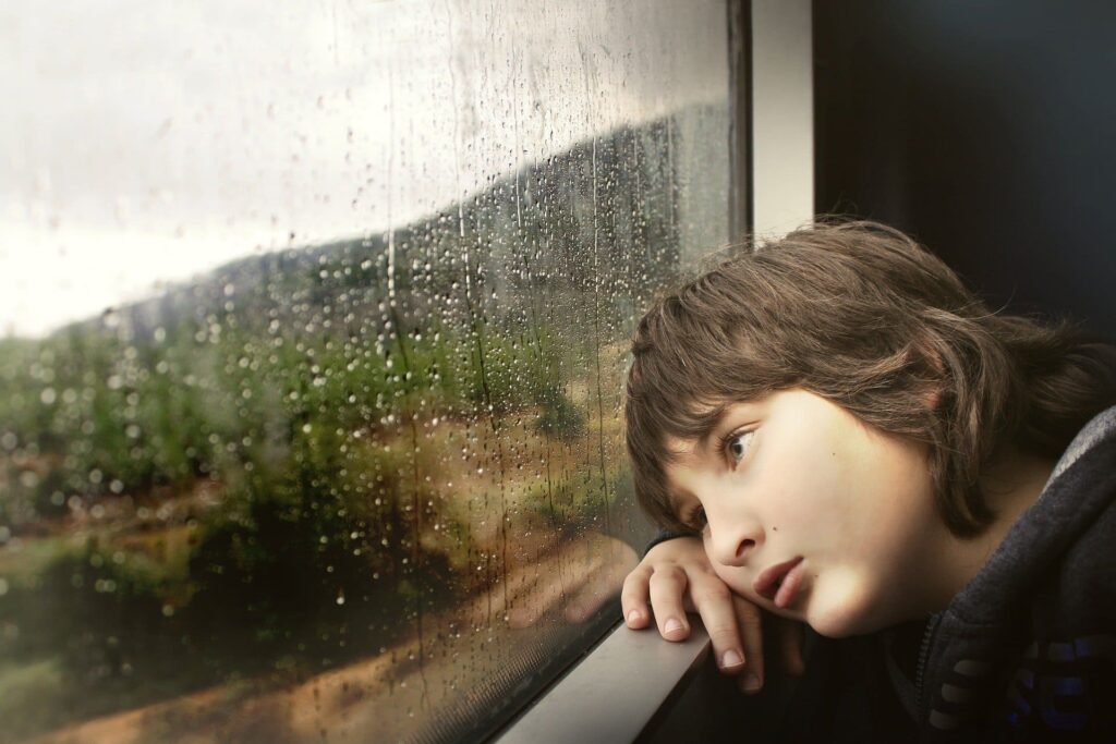 Un enfant triste et pensif qui réfléchit sur l'influence du passé sur ses choix.
