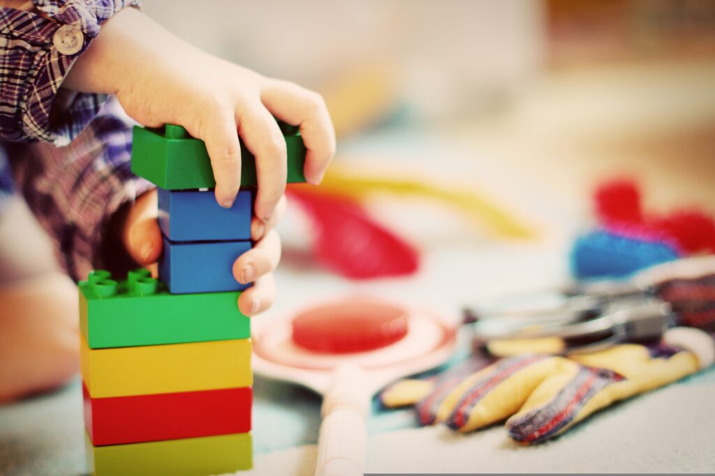 Un enfant qui joue à construire avec des legos pour tout détruire. En miroir à notre civilisation actuelle primitive qui construit pour démolir.