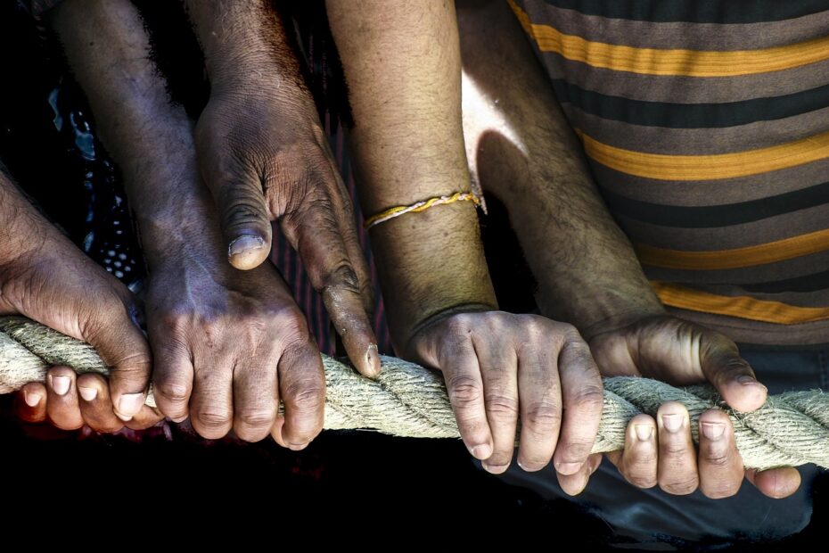 Des mains de toutes les couleurs de l'humanité s'accrochant à un bâton avec solidarité.